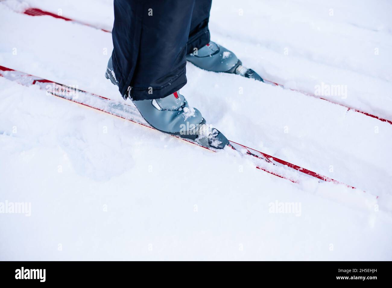 Primo piano di sci e sci. L'uomo sta sciando sulla neve d'inverno in una giornata di sole limpido Foto Stock