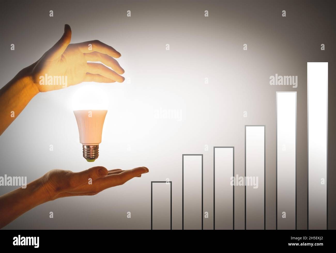 Lampada portatile. Il concetto di eco-energia, innovazione. Grafico di crescita con le mani illuminate da una lampadina a LED. Foto Stock