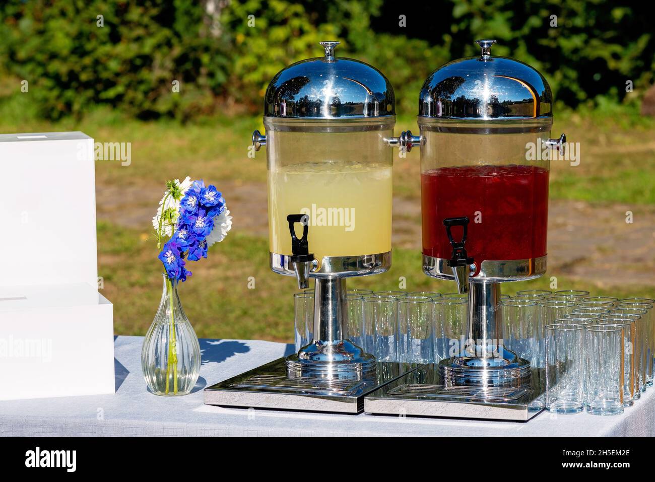 Vasetti di vetro con limonata rinfrescante e bicchieri da vino vuoti in un banchetto di nozze, Candy bar. Messa a fuoco selettiva soft. Foto Stock