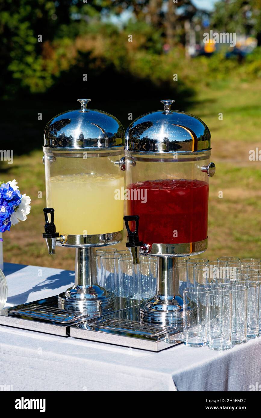 Vasetti di vetro con limonata rinfrescante e bicchieri da vino vuoti in un banchetto di nozze, Candy bar. Messa a fuoco selettiva soft. Foto Stock