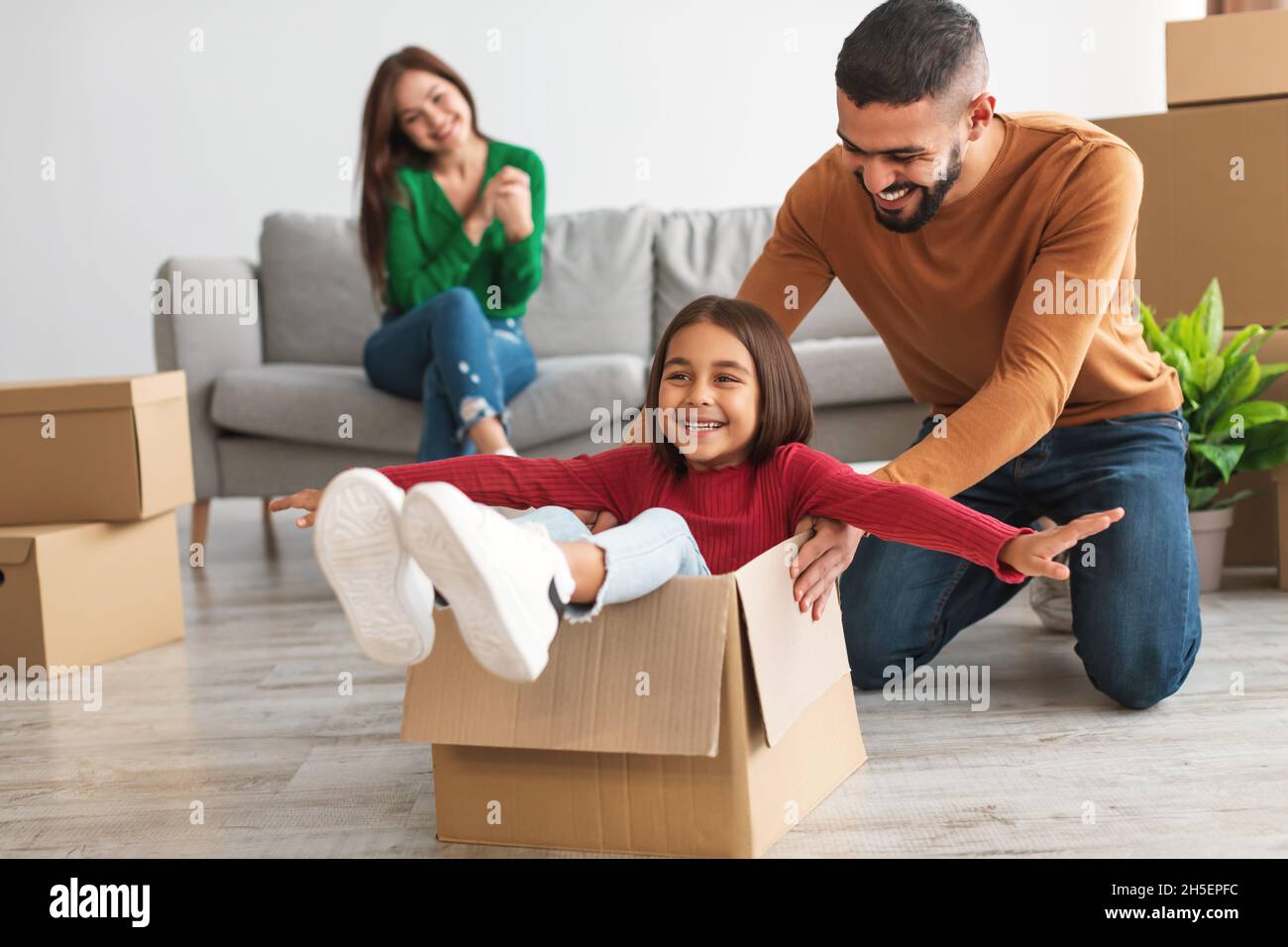 Felice famiglia che festeggia il giorno del movimento in un nuovo appartamento Foto Stock