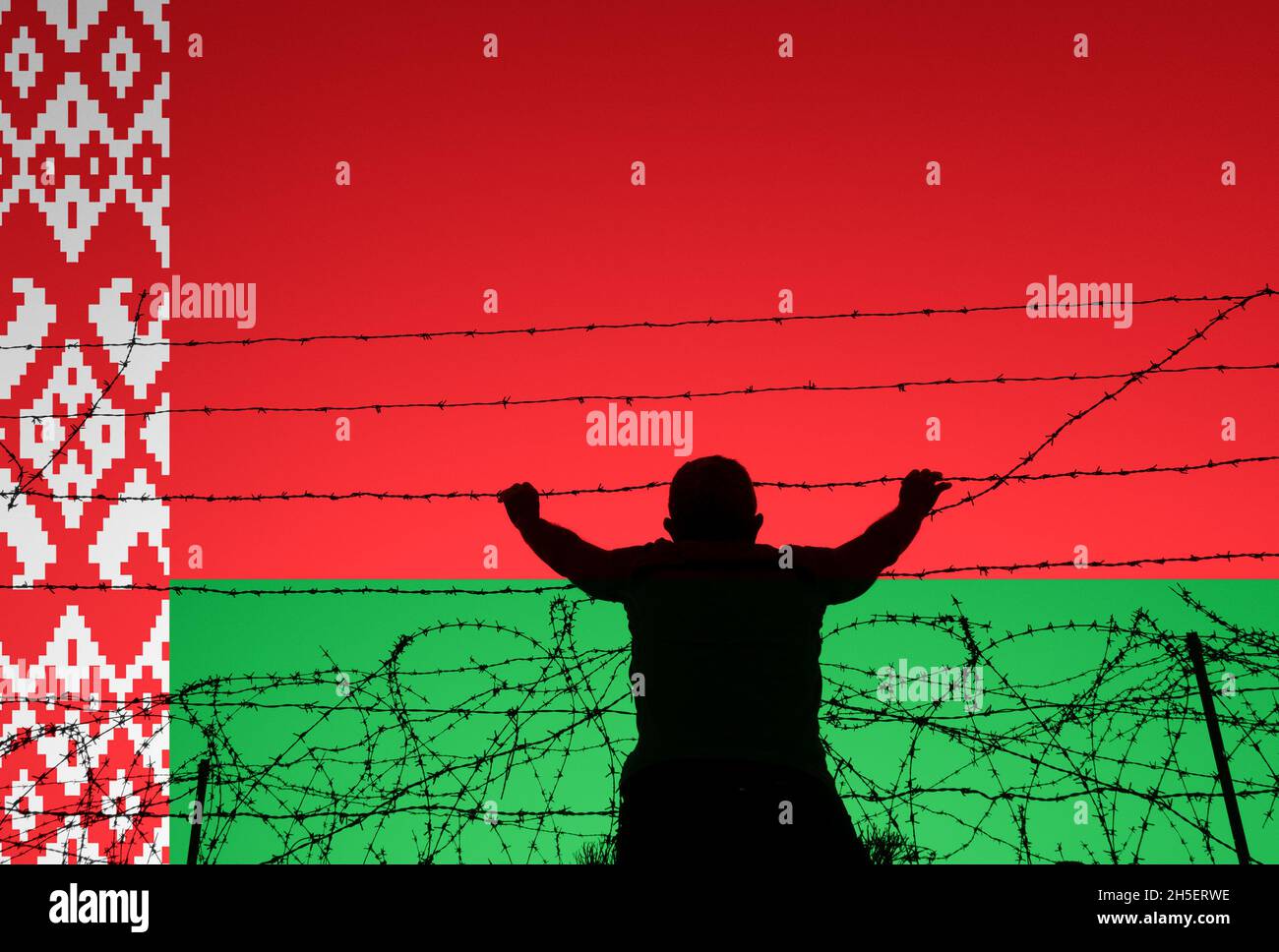Uomo che guarda attraverso recinzione filo spinato con bandiera della Bielorussia sovrastata. Confine Bielorussia/UE/Polonia, immigrati clandestini, asilo, Europa... concetto Foto Stock