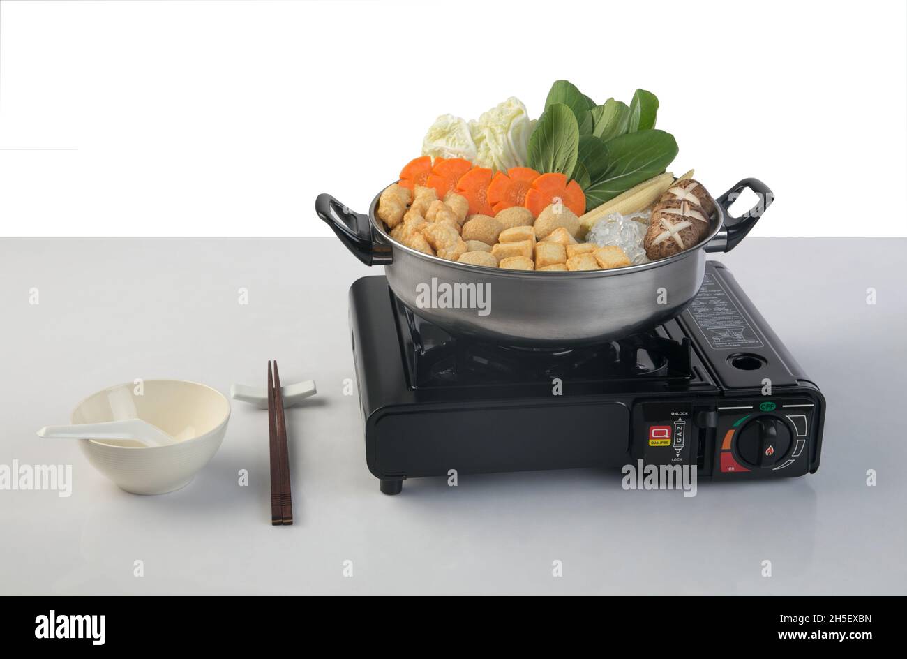 Stufa a gas turistica portatile nera con pentola sukiyaki isolata su sfondo bianco Foto Stock