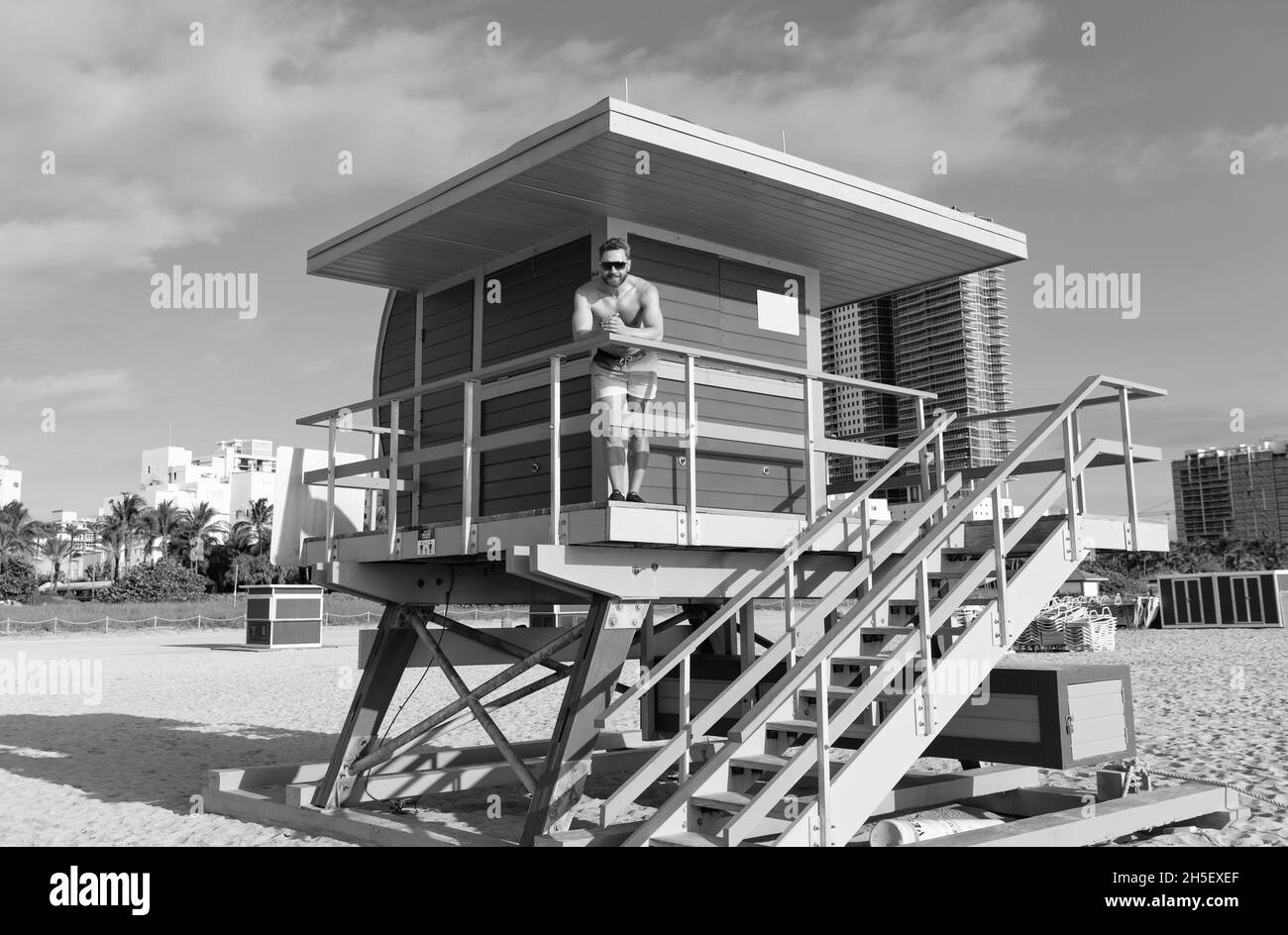 Guardia della spiaggia. L'uomo si trova sulla torre del bagnino. Vacanza in spiaggia. Pausa estiva. Vacanze al mare Foto Stock