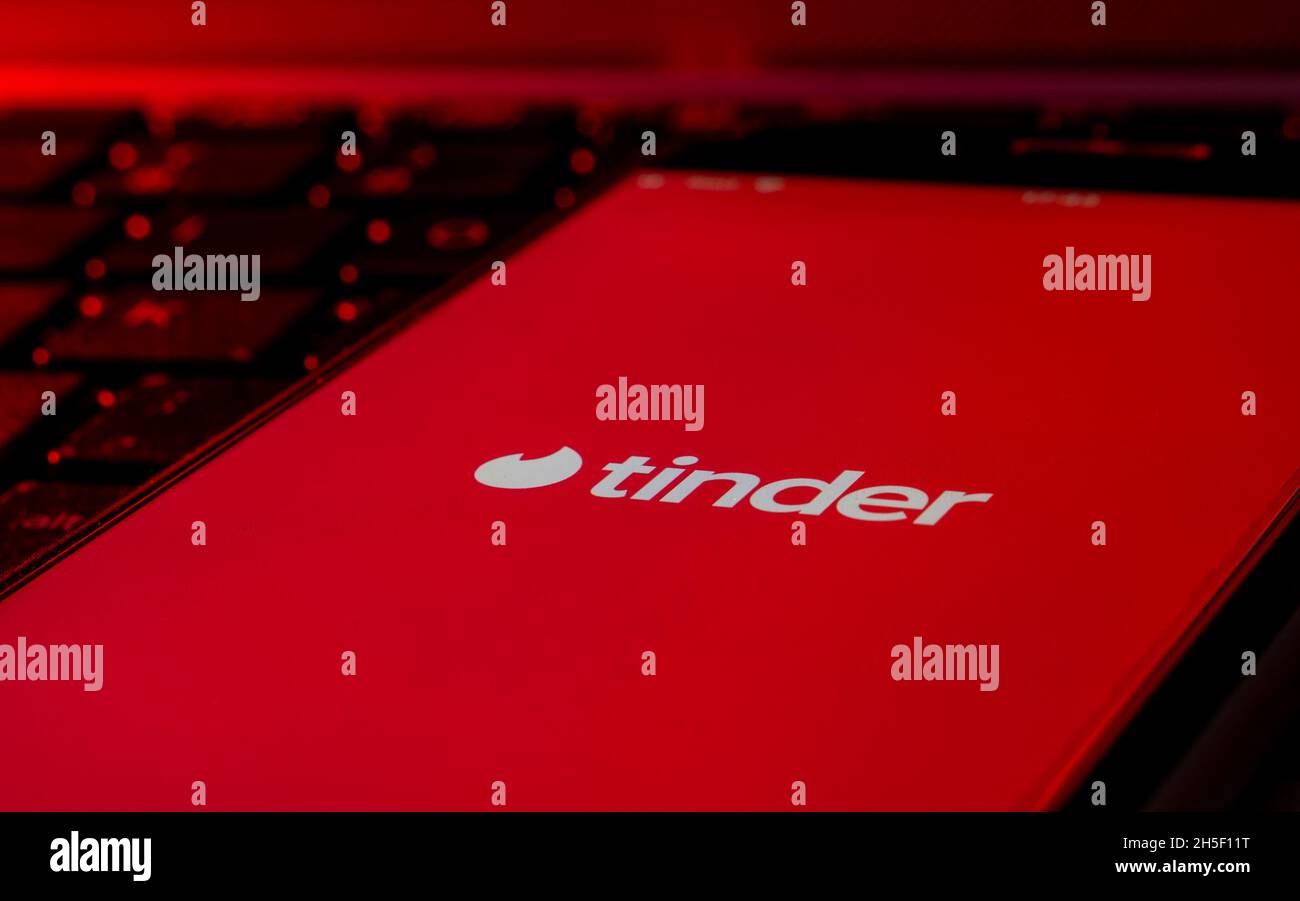 Smartphone su una tastiera del computer con il logo dell'app Tinder Dating Foto Stock