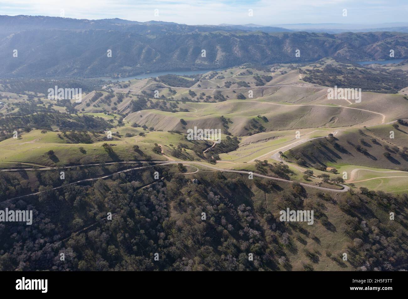 Alte nuvole e cieli blu formano un baldacchino sulle tranquille colline di Livermore, California. Nei mesi invernali, questa regione passa dal marrone al verde. Foto Stock