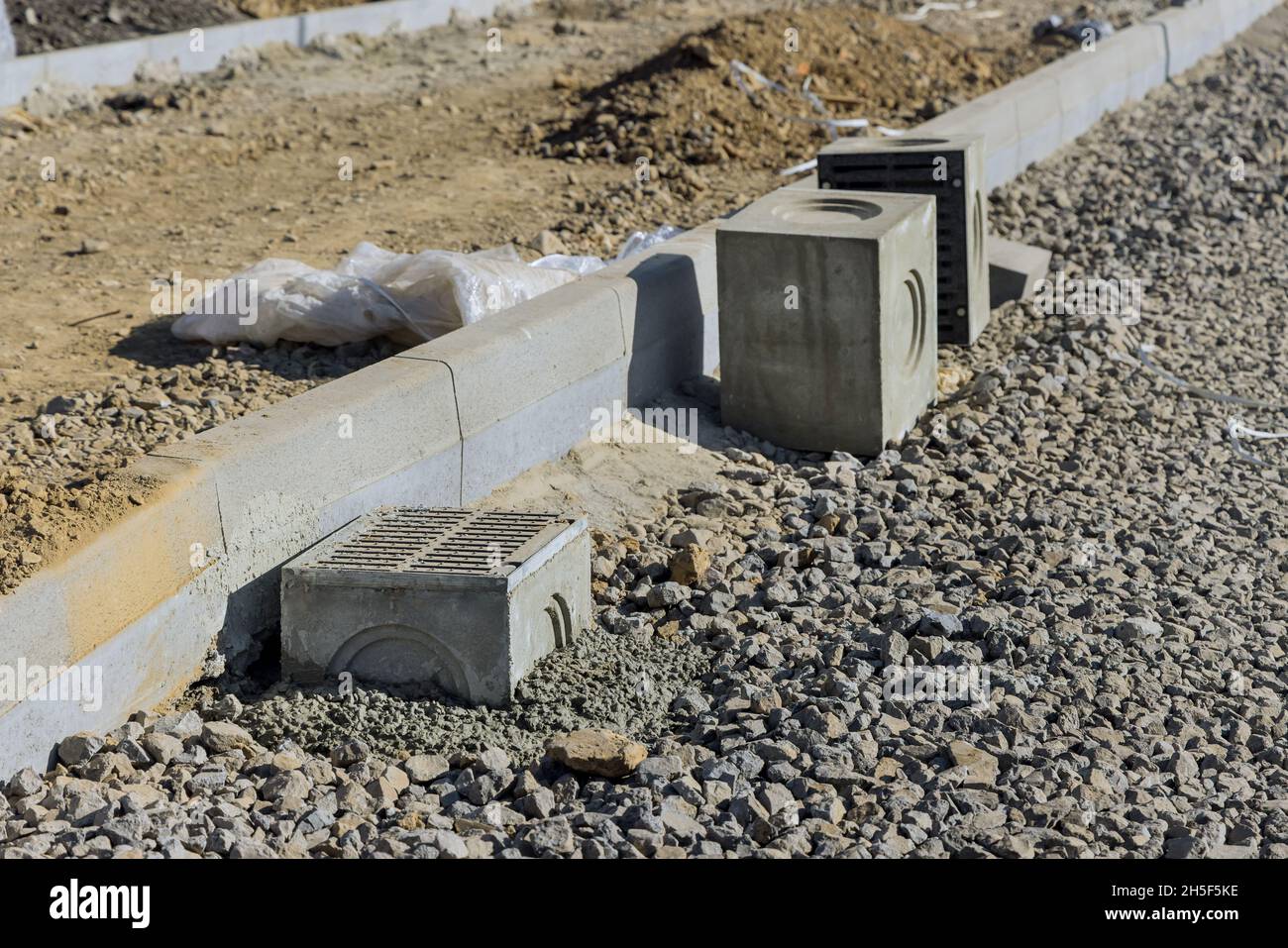 Costruzione di pavimentazioni, grata su un pozzo per una base in calcestruzzo durante il drenaggio dell'acqua di posa Foto Stock