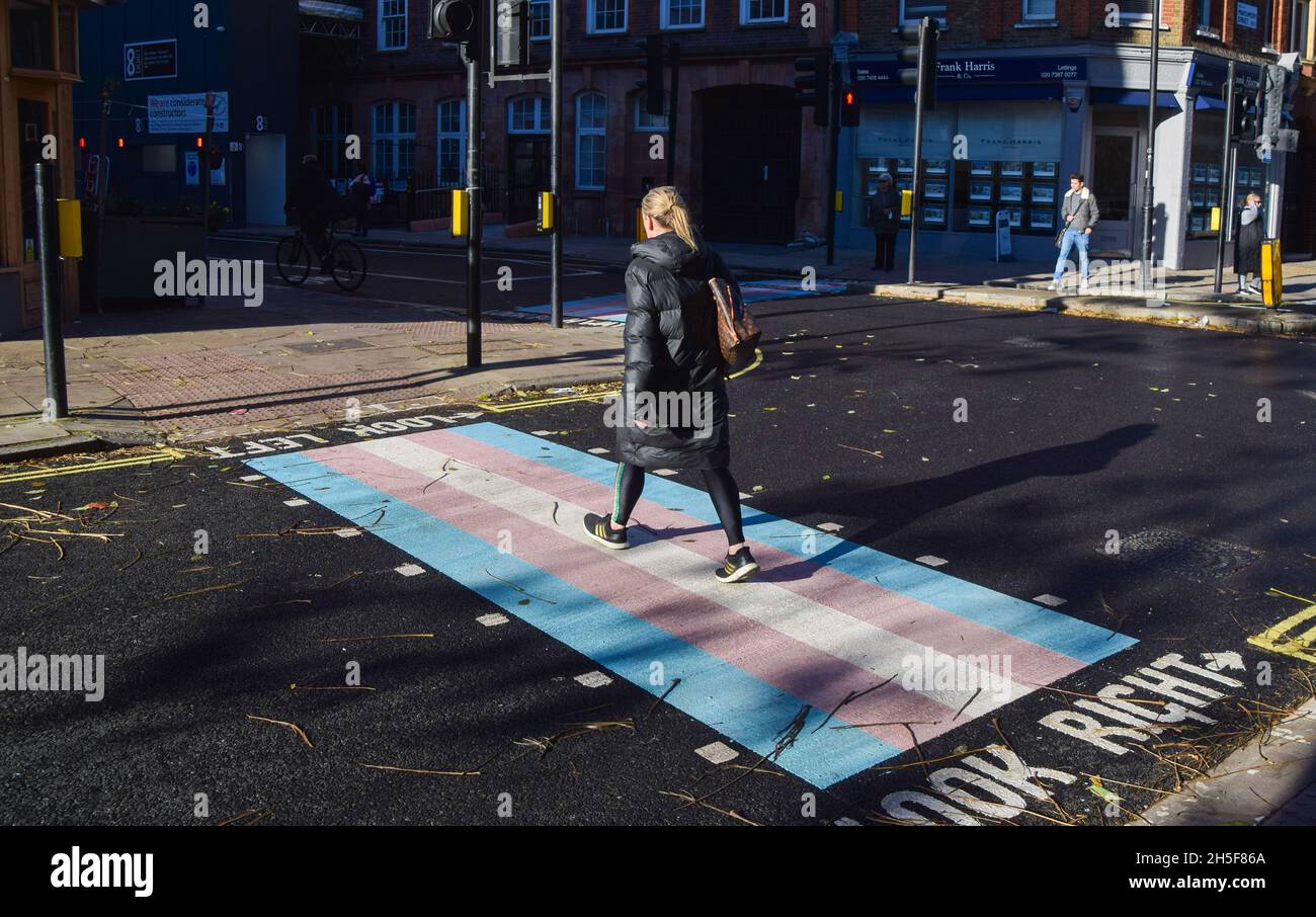 Una donna cammina lungo un attraversamento pedonale con i colori della bandiera trans a Bloomsbury.quattro nuovi incroci con colori della bandiera trans sono stati svelati su Marchmont Street e Tavistock Place, a sostegno della comunità trans. Foto Stock