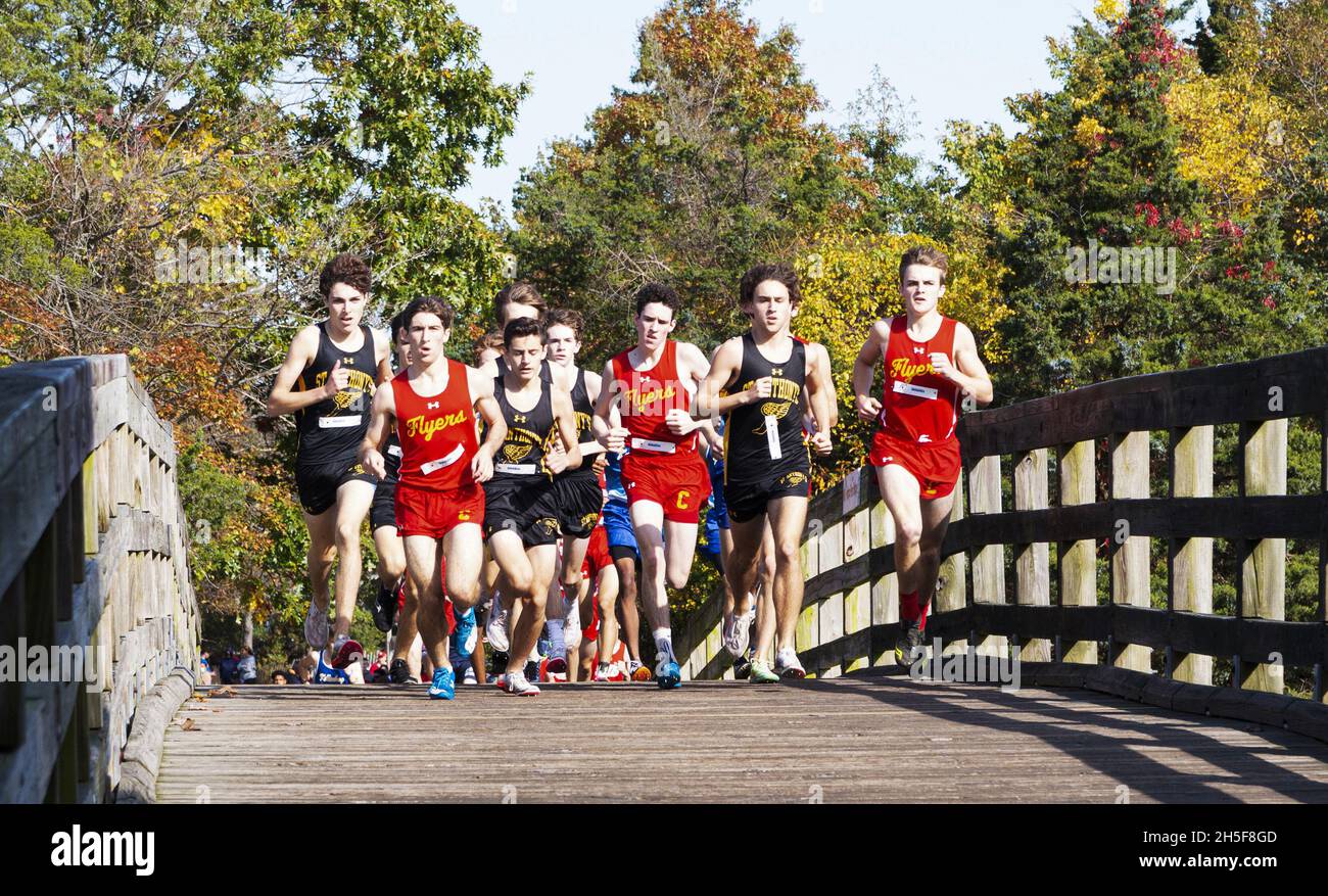 Kings Park, New York, USA - 31 ottobre 2021: L'inizio di una gara di cross country con i ragazzi delle scuole superiori che corrono sul ponte di legno a Sunke Foto Stock