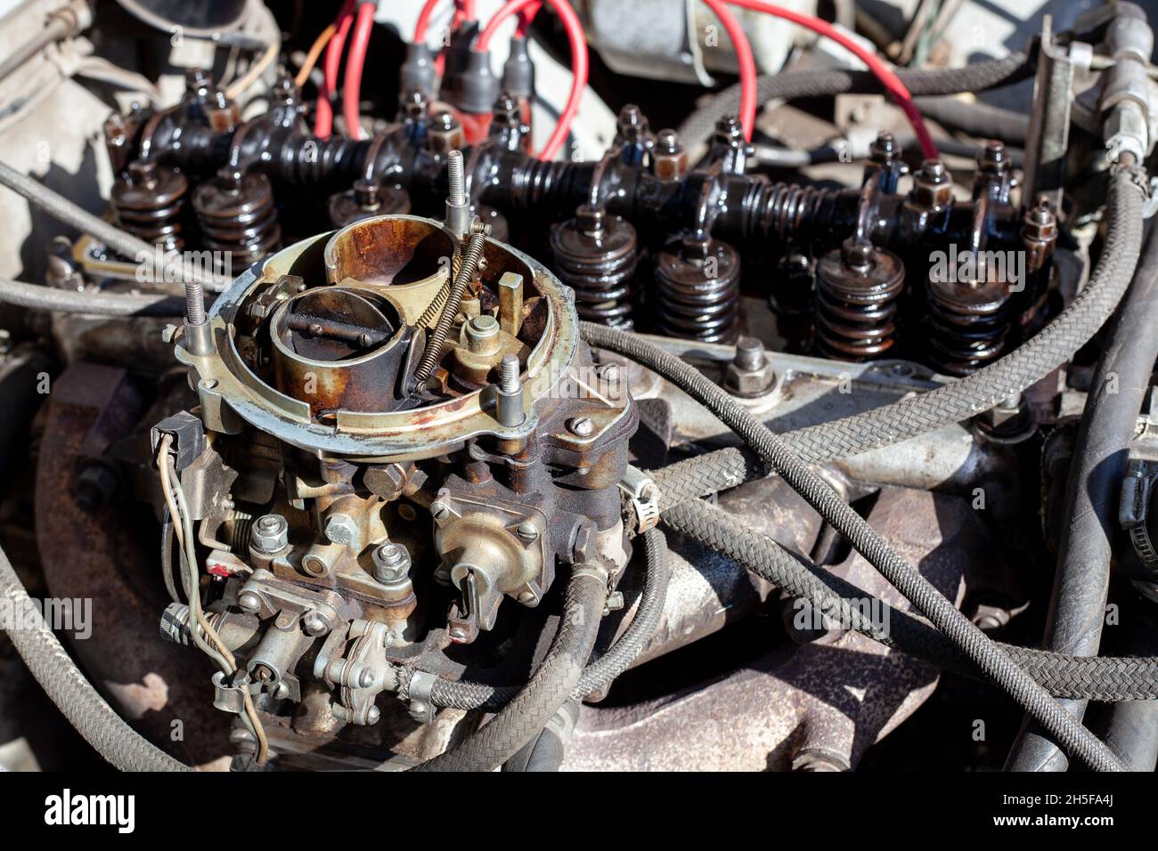 Smontaggio del carburatore sul vecchio motore senza parte superiore e filtro dell'aria. Manutenzione e riparazione del motore del carburatore. Pulizia dell'impianto di alimentazione. Primo piano Foto Stock