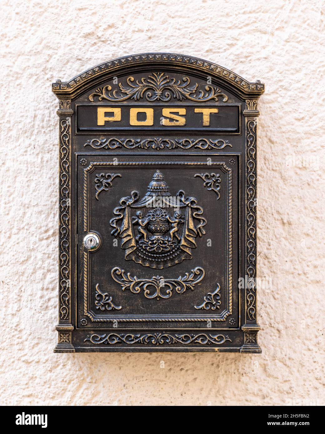 Vecchia mailbox vintage sul muro con moderno lucchetto in nero e oro Foto Stock