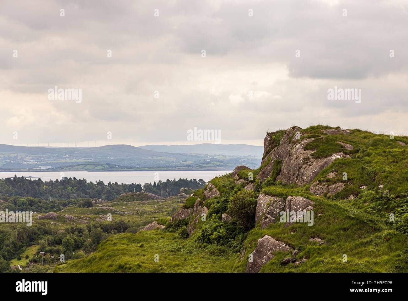 Rocce di granito sulle aspre colline della Riserva Naturale di Glengarriff Woods, Glengarriff, County Cork, Irlanda Foto Stock