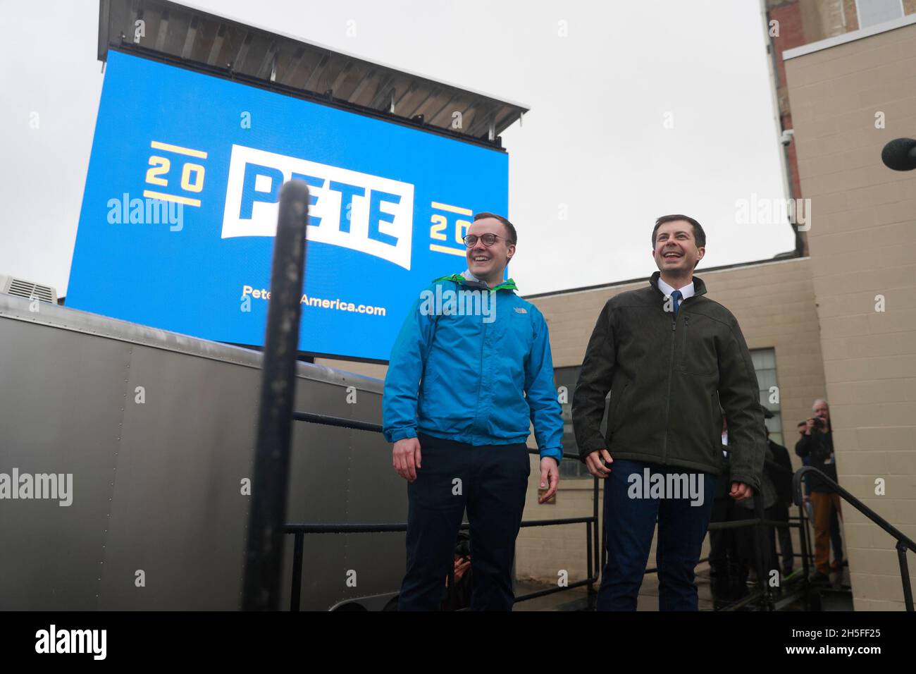 South Bend, il sindaco dell'Indiana Pete Buttigieg, in piedi con il marito Chasten Buttigieg, parla con la folla di overflow in piedi sotto la pioggia prima di annunciare che è in esecuzione per il presidente degli Stati Uniti nelle elezioni del 2020 durante un evento di campagna Domenica a Studebaker Building 84. Foto Stock