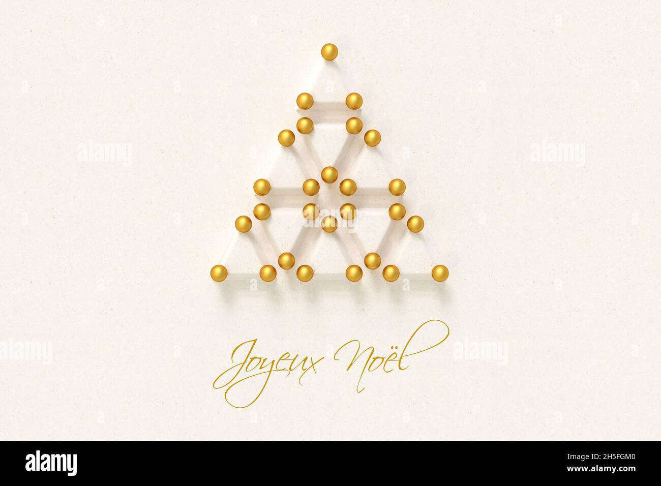 Albero di Natale fatto da triangoli di carta e baubles dorati. Messaggio francese "Joyeux Noël" (buon Natale) qui sotto. Foto Stock