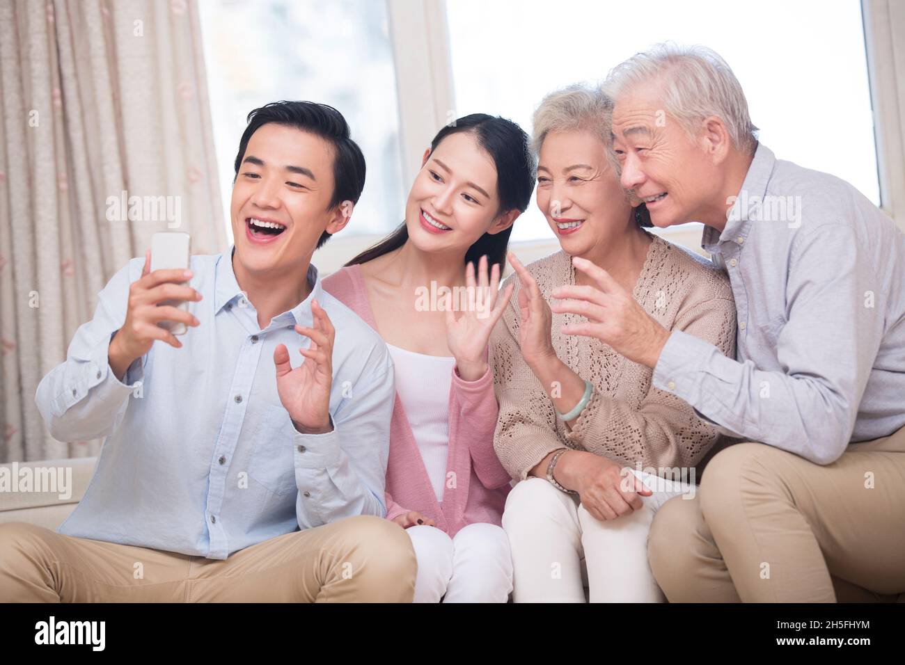 Famiglia felice che ha videochiamata sul loro telefono delle cellule Foto Stock