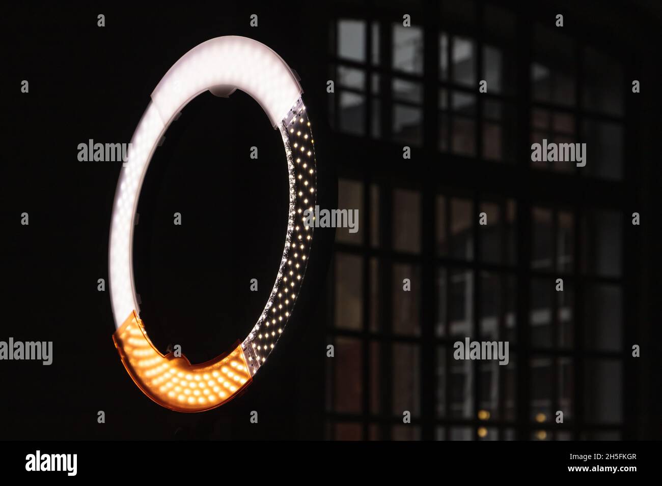 Luce a LED circolare che si illumina in uno studio fotografico scuro, foto ravvicinate con messa a fuoco selettiva Foto Stock