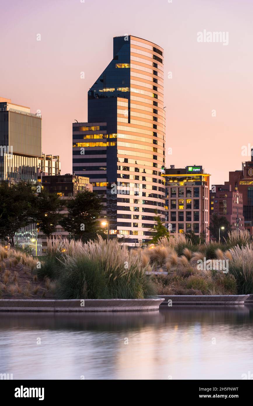 Santiago del Cile, Regione Metropolitana, Cile - Stagno al Parco del Bicentenario nel ricco quartiere Vitacura e skyline di costruzione Foto Stock