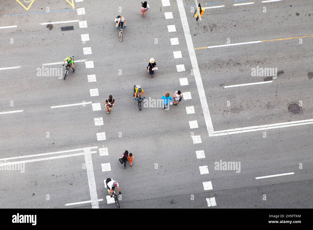 Fußgänger und Radfahrer (keine Erkennbarkeit) auf einer grauen Verkehrsstraße mit weißen gestrichelten Linien. Keine Autos (Autos. Carina) Aus der Vogelperspektive. Foto Stock