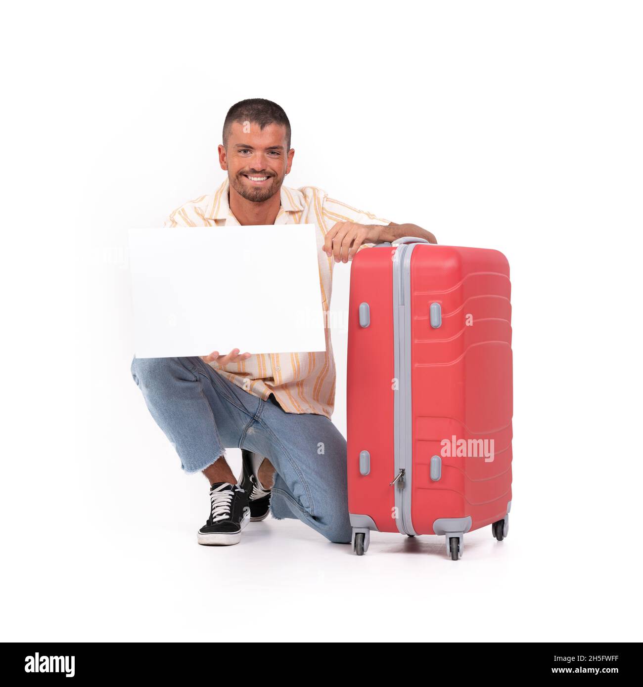 Felice uomo giovane con una valigia da viaggio e un poster vuoto su sfondo  bianco Foto stock - Alamy