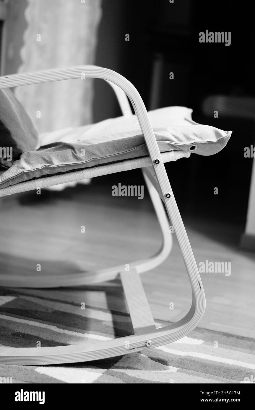 POZNAN, POLONIA - Mar 23, 2018: Una scala di grigi di un dettaglio di sedia Swing in una stanza in colori monocromatici a Poznan, Polonia Foto Stock