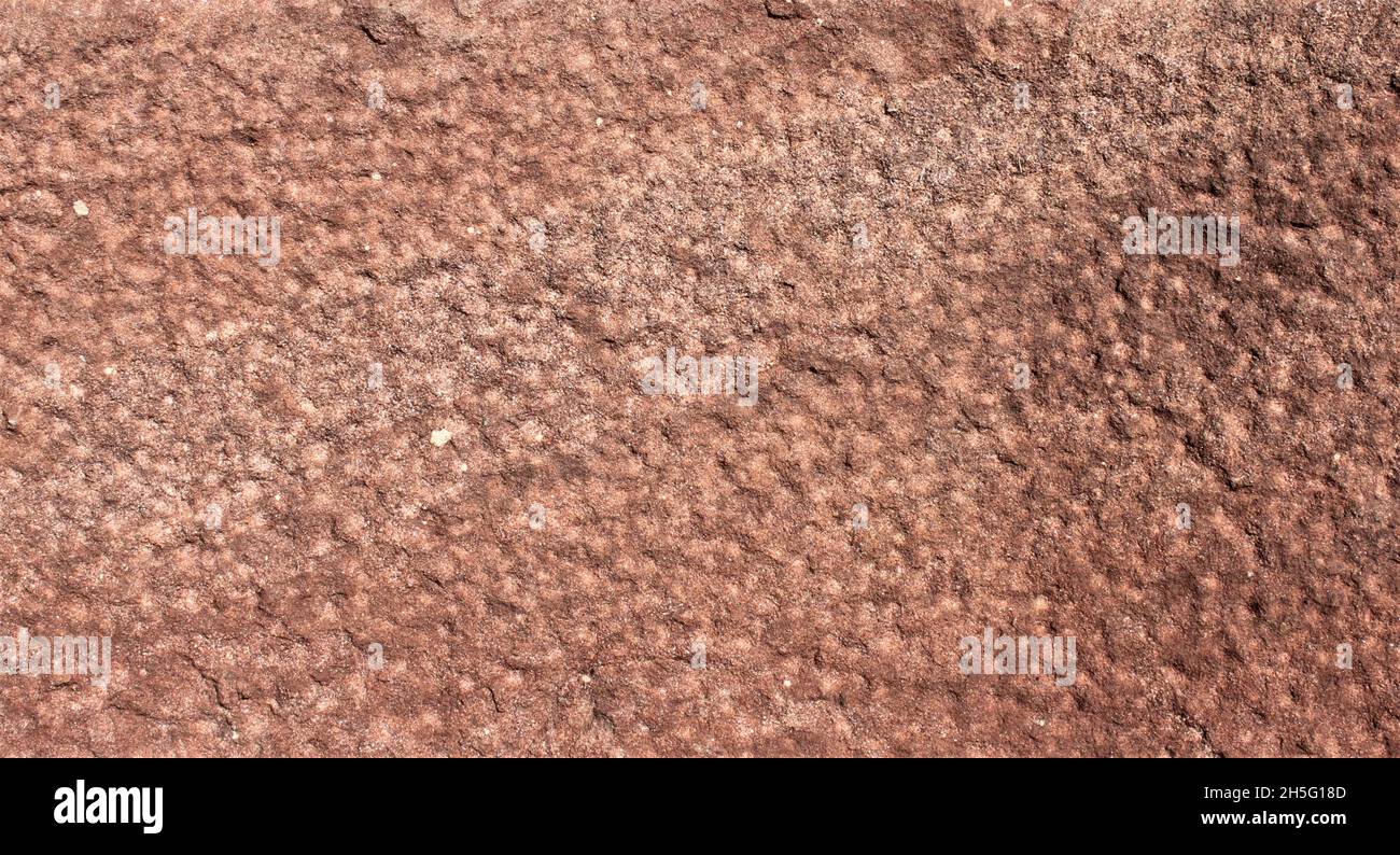 primo piano di una superficie di pietra arenaria a motivi irregolarmente rossa e marrone Foto Stock
