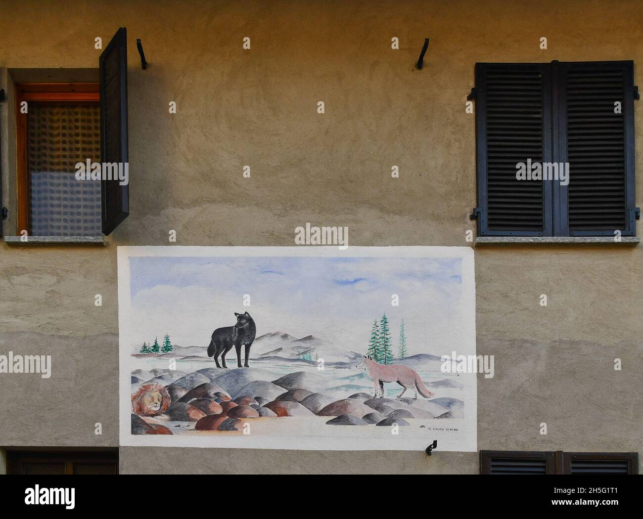 Murale di strada dedicato al lupo sulla facciata di una vecchia casa nel piccolo villaggio di Montelupo Albese, Langhe (sito UNESCO), Piemonte, Italia Foto Stock