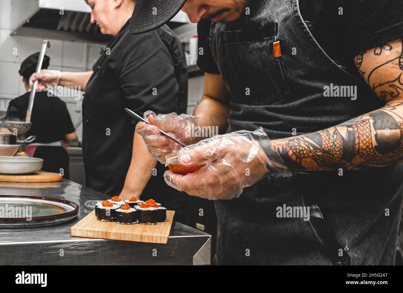 cuochi maschili che preparano il sushi nella cucina del ristorante. Foto Stock