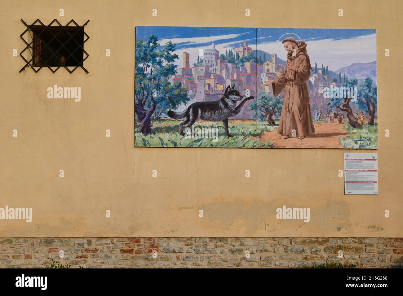 Murale raffigurante San Francesco d'Assisi insieme al lupo di Gubbio, nel piccolo borgo sulle colline delle Langhe, Montelupo Albese, Cuneo, Piemonte Foto Stock