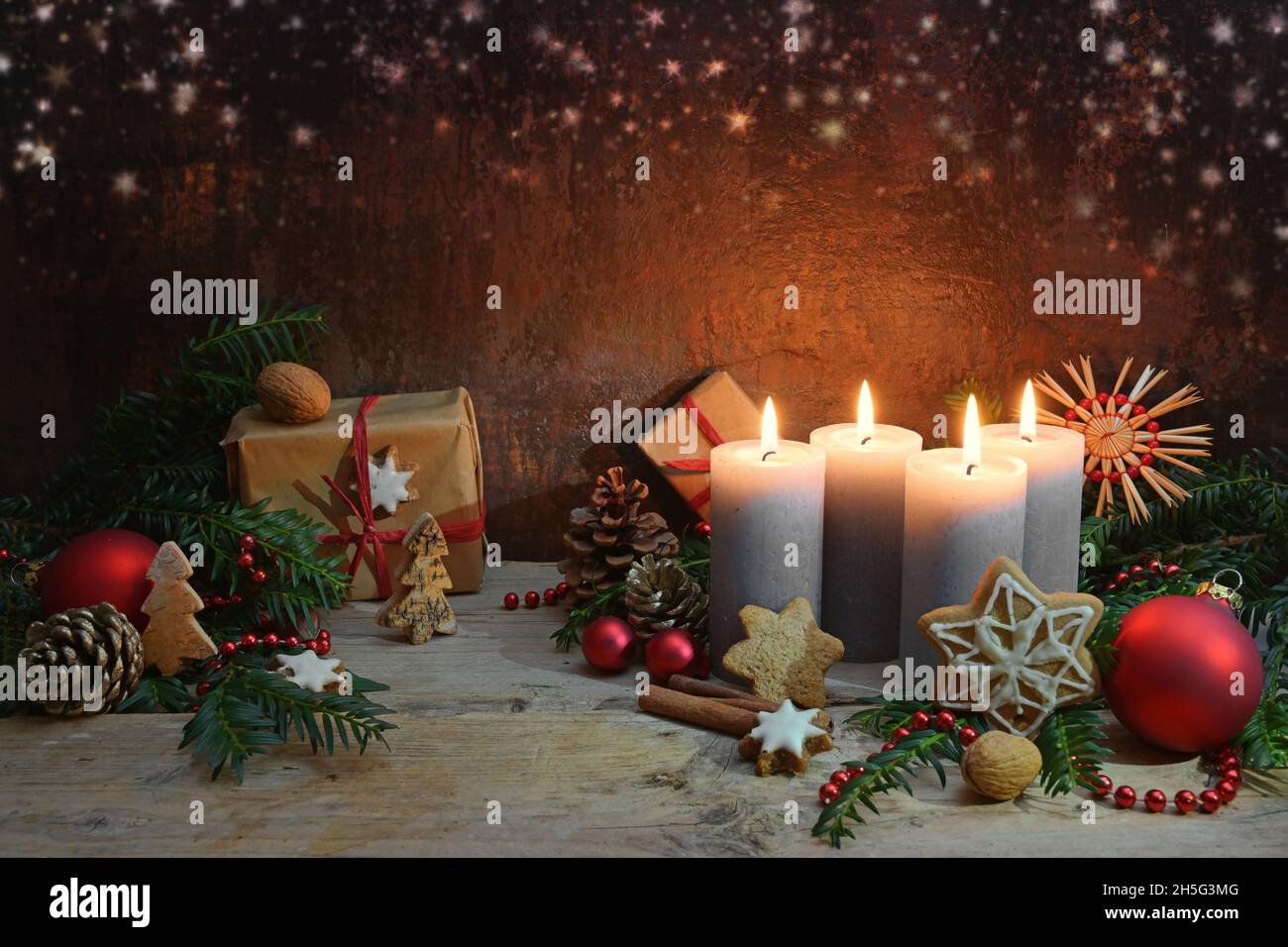 Quarto Avvento, quattro candele sono accese, decorazione di Natale e regali su tavole rustiche di legno su uno sfondo marrone scuro con spazio copia, selec Foto Stock