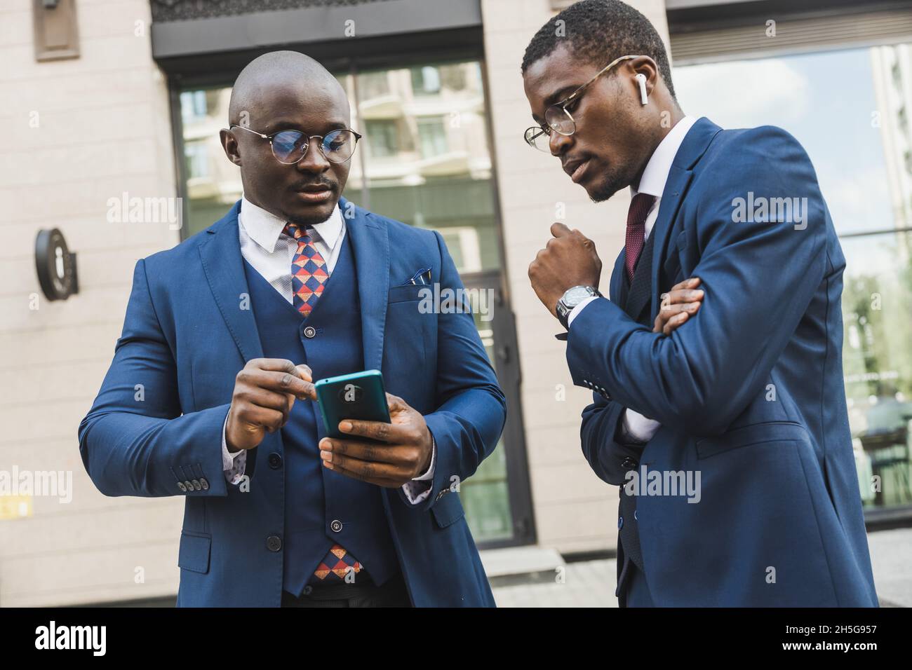 Incontro di due partner nero afroamericano uomo d'affari in abiti e bicchieri all'aperto Foto Stock