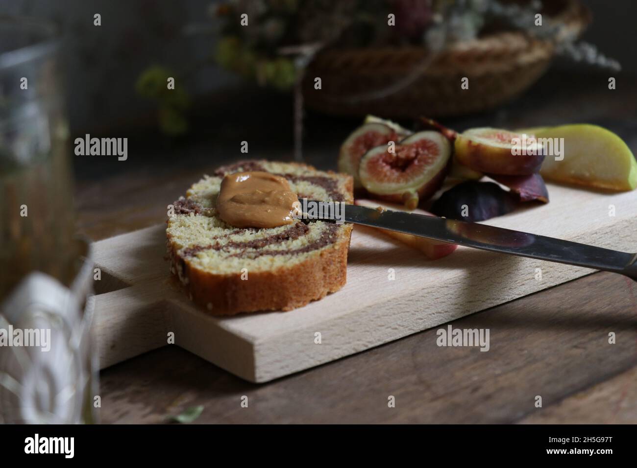 Vassoio di legno con fichi e pere succosi a fette e una torta con crema al cioccolato Foto Stock