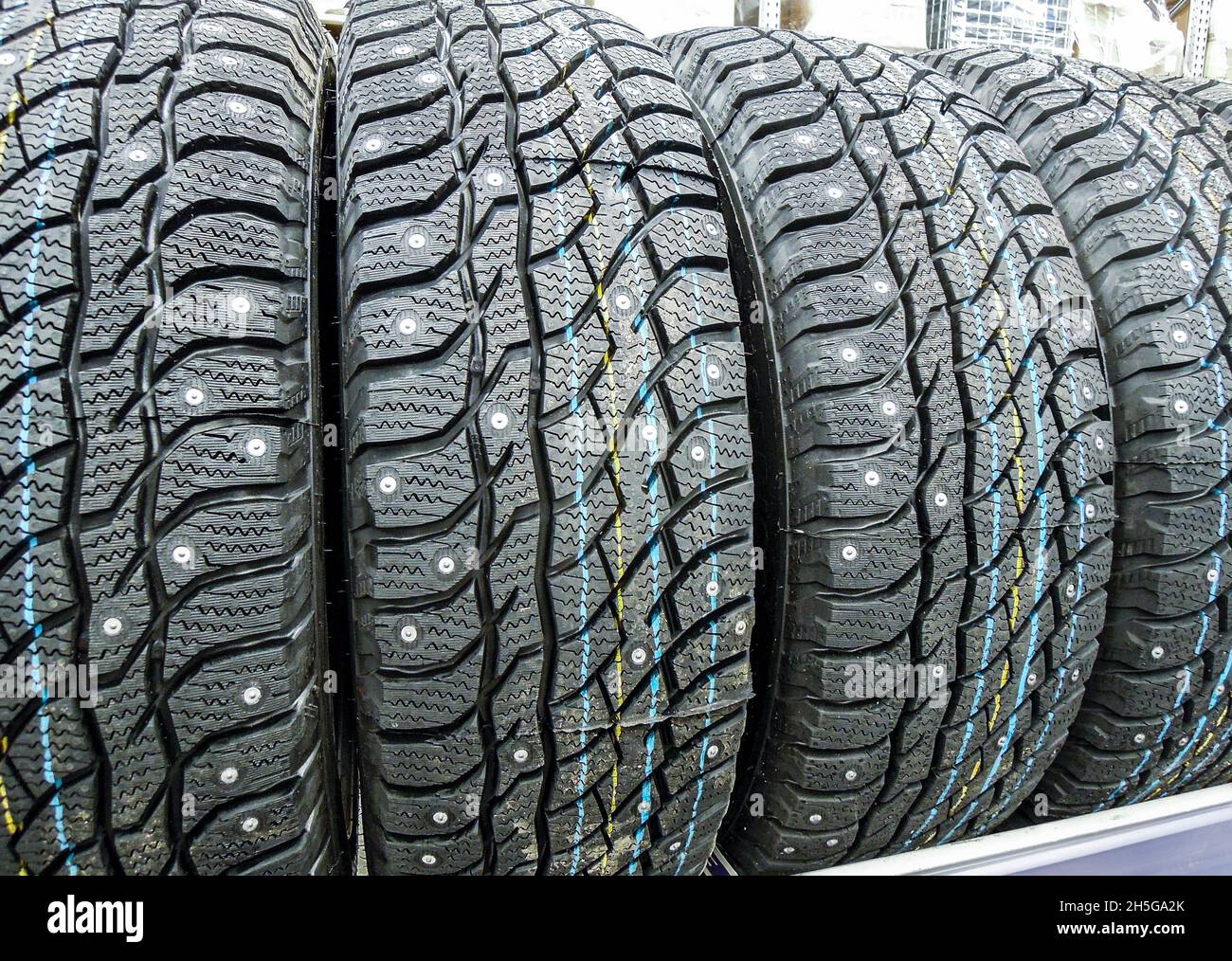 Inverno pneumatici del veicolo impilate in su per la vendita nella catena  ipermercati. Nuovi pneumatici chiodati per la vendita Foto stock - Alamy