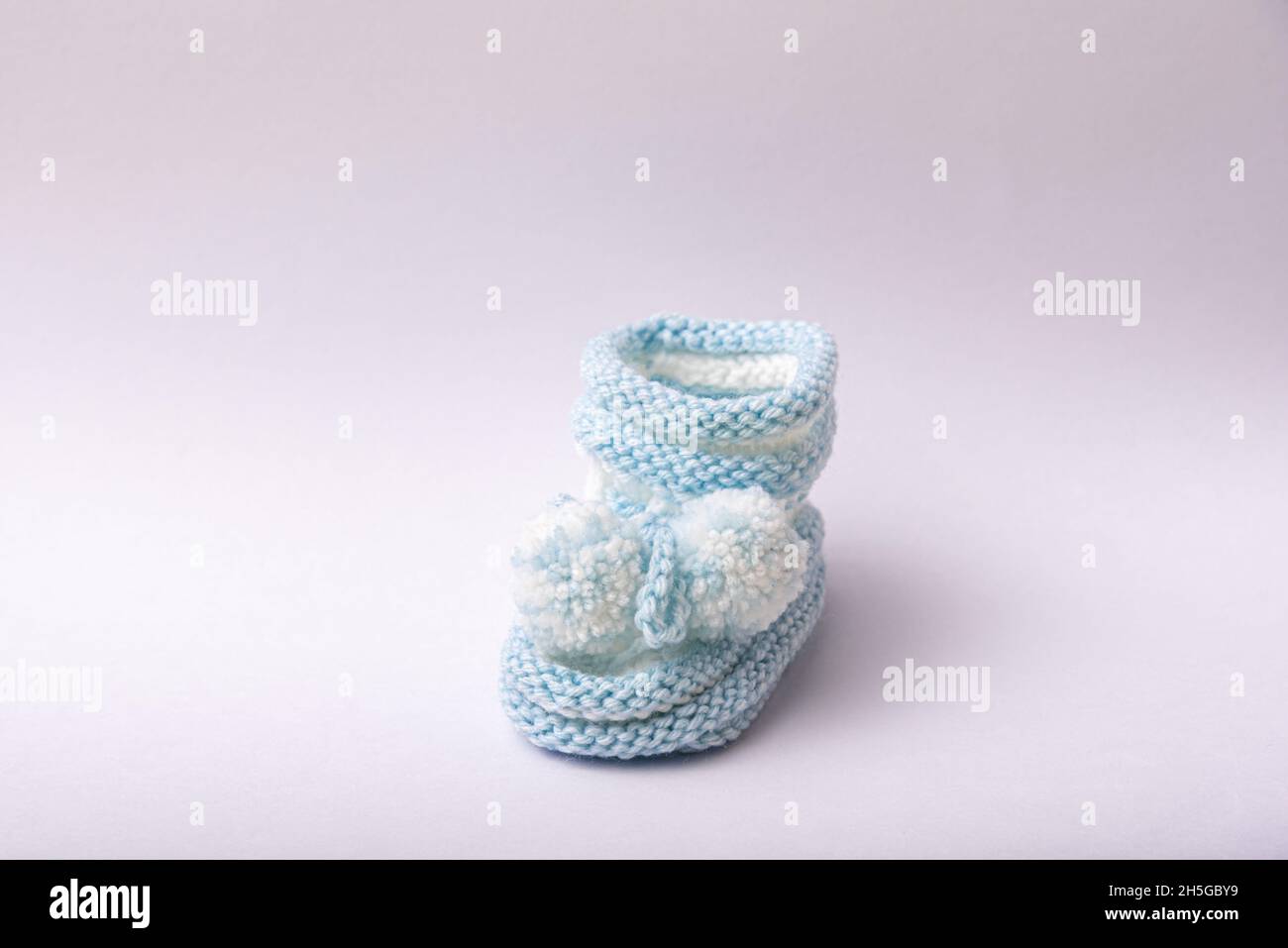 scarpe in maglia casereccia per i neonati su sfondo bianco Foto Stock