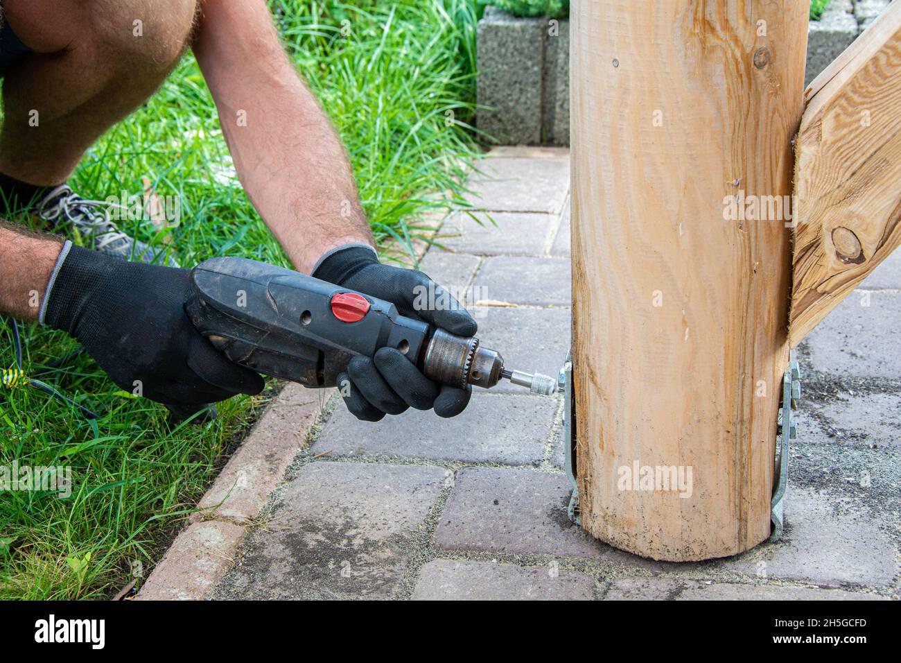 Gli operatori che indossano i guanti devono utilizzare un cacciavite elettrico per serrare la vite. Foto Stock