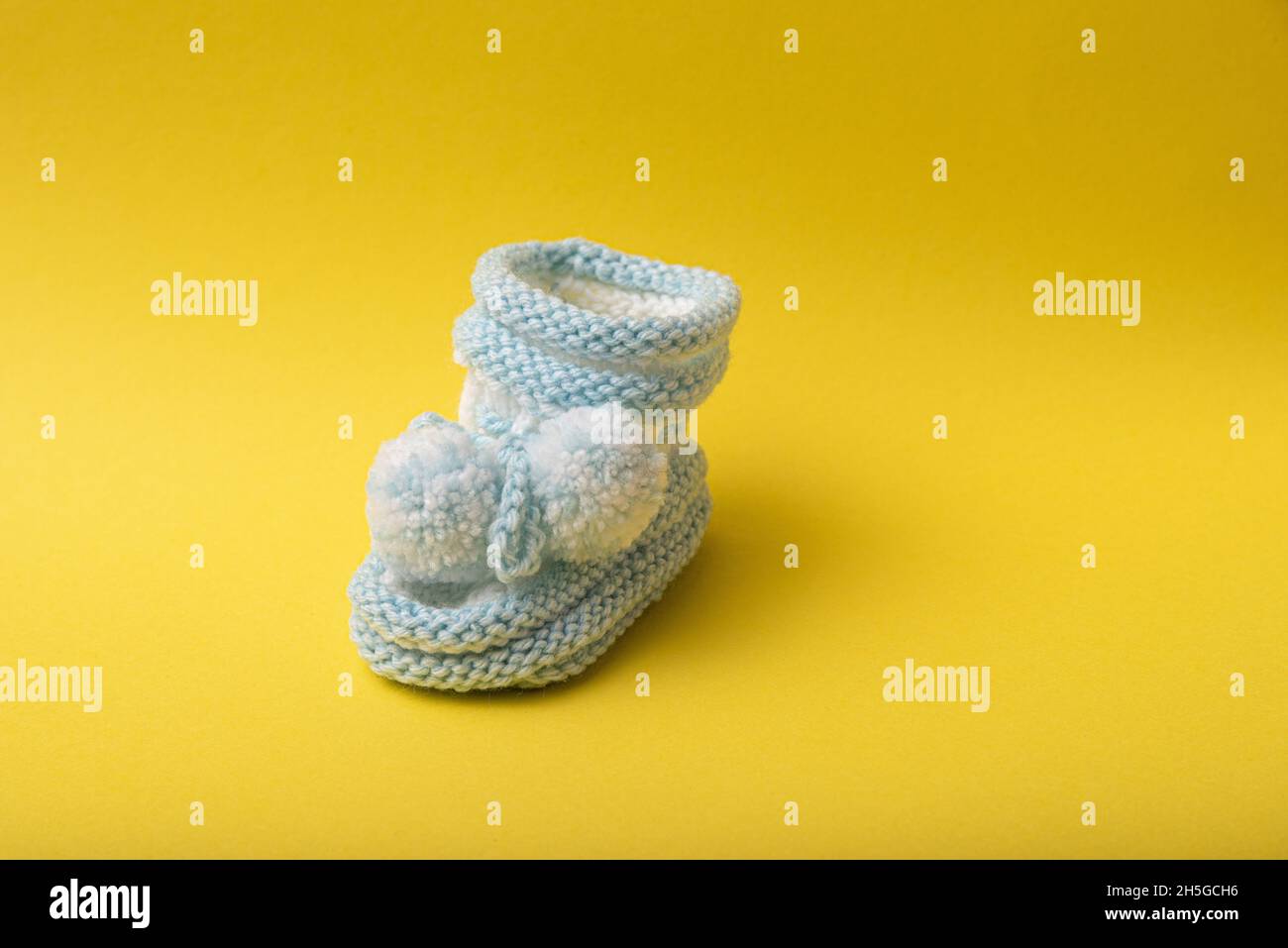 scarpe caserecce per neonati su sfondo giallo Foto Stock