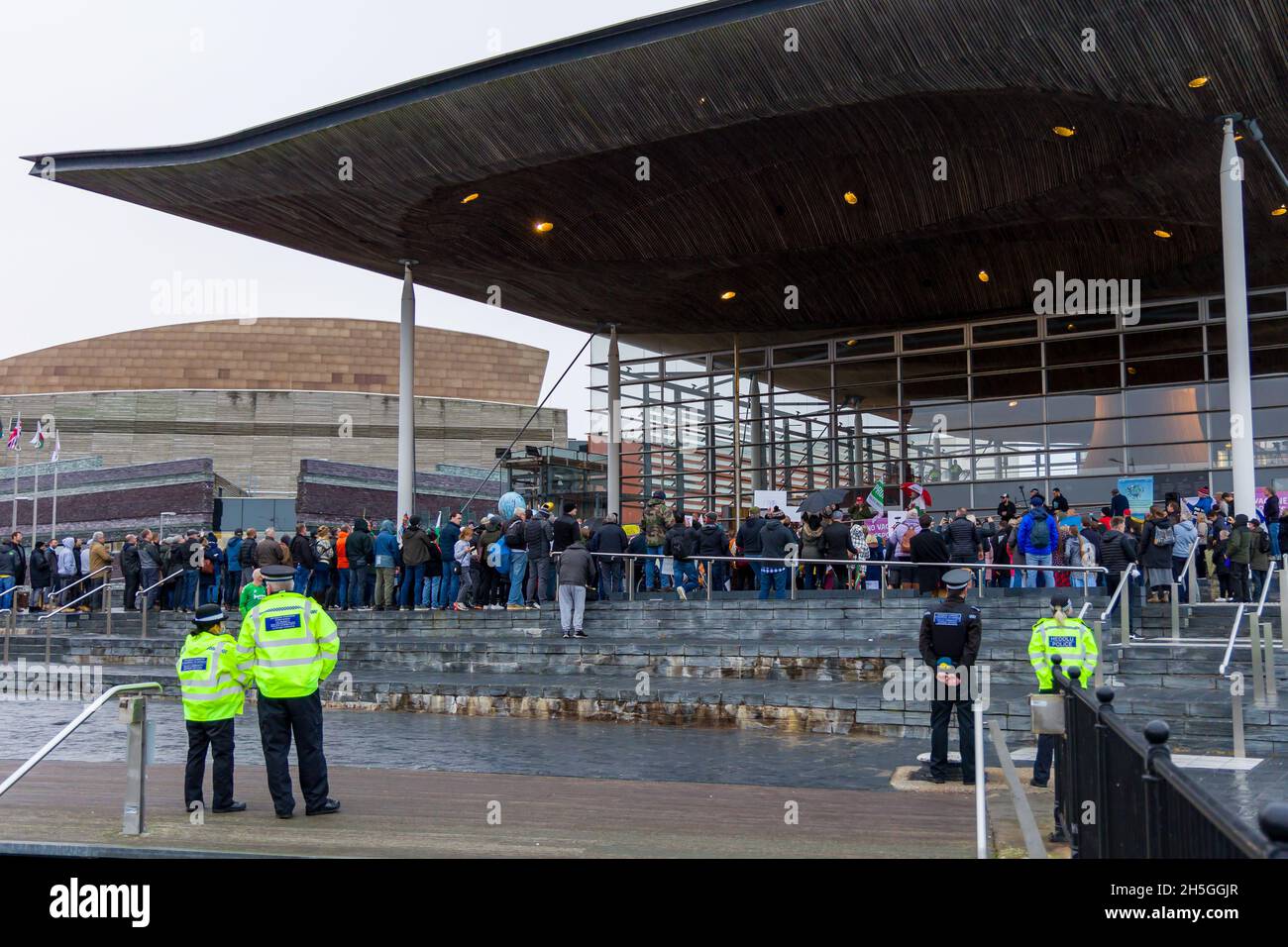 CARDIFF, GALLES - NOVEMBRE 09 2021: Ufficiali della polizia del Galles del Sud osservano una manifestazione contro i passaporti dei vaccini covidi al Parlamento gallese Foto Stock