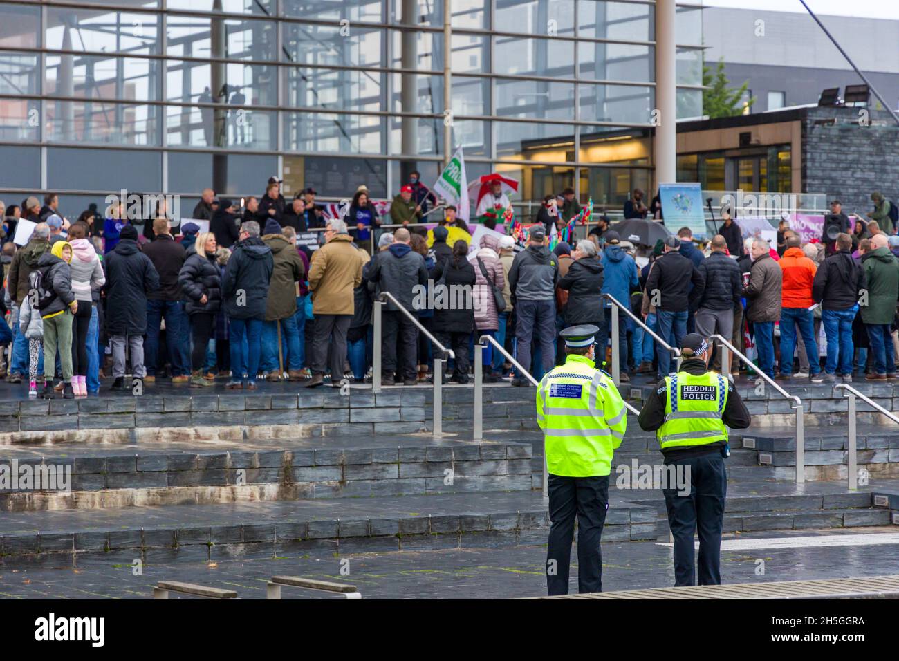 CARDIFF, GALLES - NOVEMBRE 09 2021: Ufficiali della polizia del Galles del Sud osservano una manifestazione contro i passaporti dei vaccini covidi al Parlamento gallese Foto Stock