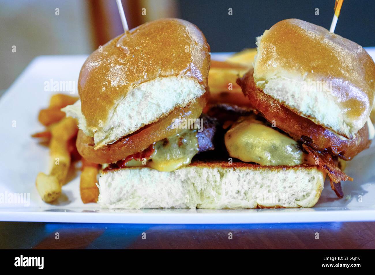 Anelli di cipolla sui cursori del Cheeseburger Foto Stock
