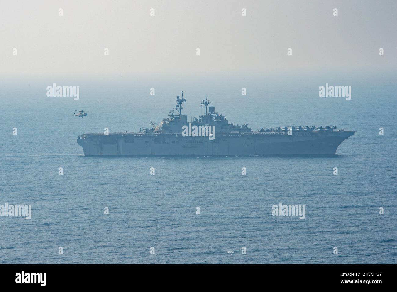 GOLFO D'OMAN (NOV. 8, 2021) Royal Navy Merlin Mk4 attaccato a 845 Naval Air Squadron, schierato con la Royal Navy Aircraft Carrier HMS Queen Elizabeth, conduce operazioni di volo con la nave d'assalto anfibio USS Essex (LHD 2) durante un esercizio di interoperabilità con Queen Elizabeth, 8 novembre. L'Essex e l'undicesima unità Marine Expeditionary sono dislocate nell'area della 5th Fleet degli Stati Uniti di operazioni a sostegno delle operazioni navali per garantire la stabilità e la sicurezza marittima nella regione centrale, collegando il Mediterraneo e il Pacifico attraverso l'Oceano Indiano occidentale e tre poin strategico di choke Foto Stock