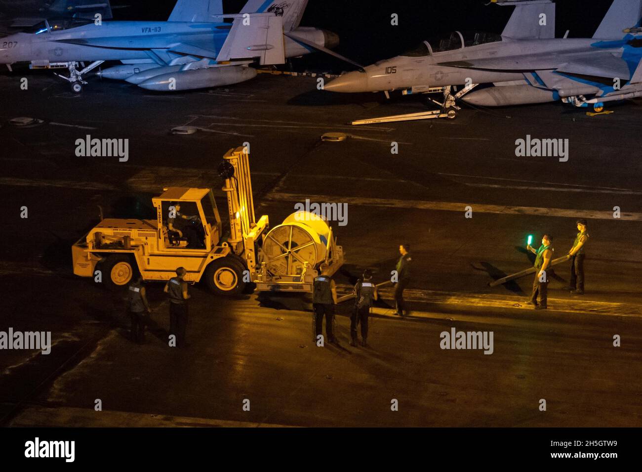 211107-N-RO680-1015 MAR DELLE FILIPPINE (NOV. 7. 2021) i marinai si preparano ad abbassare le macchine sul ponte di volo del vettore aereo di classe Nimitz USS Carl Vinson (CVN 70), 7 novembre 2021. Carl Vinson Carrier Strike Group è in fase di implementazione nell'area operativa della 7a flotta statunitense per migliorare l'interoperabilità attraverso alleanze e partnership, fungendo da forza di risposta pronta a supportare una regione indopacifica libera e aperta. (STATI UNITI Foto Navy di Mass Communication Specialist terza classe Erin C. Zorich) Foto Stock