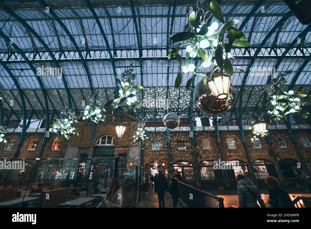 Le luci di Natale di Covent Garden sono state accese il 9 novembre 2021. La neve cadde attraverso gli acquirenti mentre scattavano foto dell'albero. L'albero è dotato di 50,000 luci a LED. Foto Stock