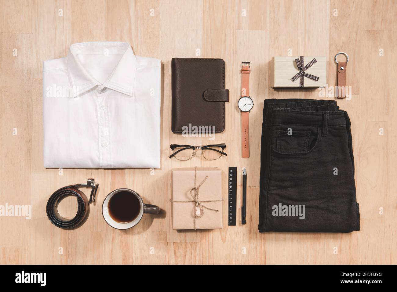 Hand watch, shirt, coffee cup, notebook and male accessories on wooden background floor backround. Foto Stock