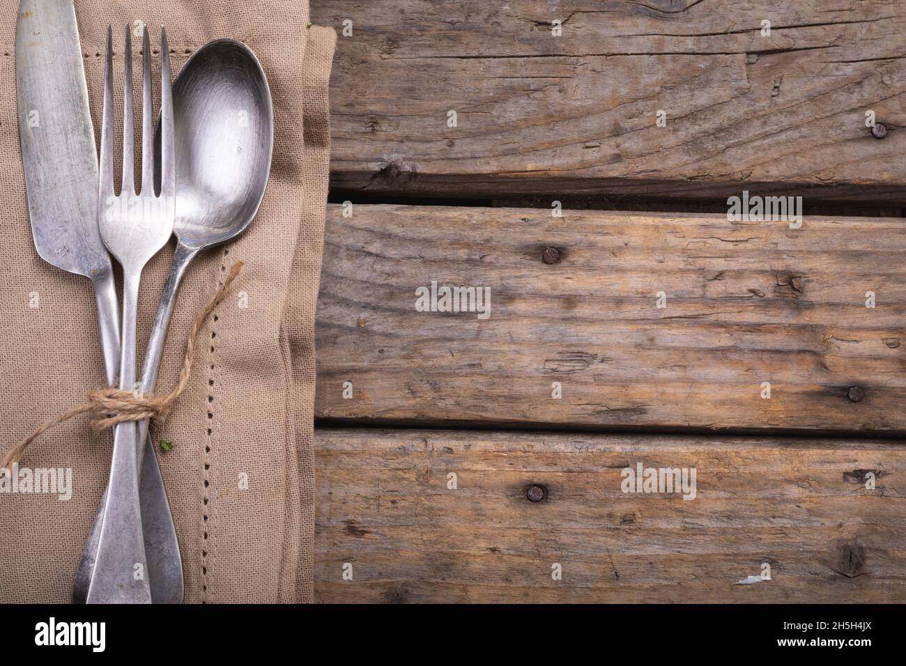 Primo piano di posate su un tovagliolo su una superficie di legno Foto Stock
