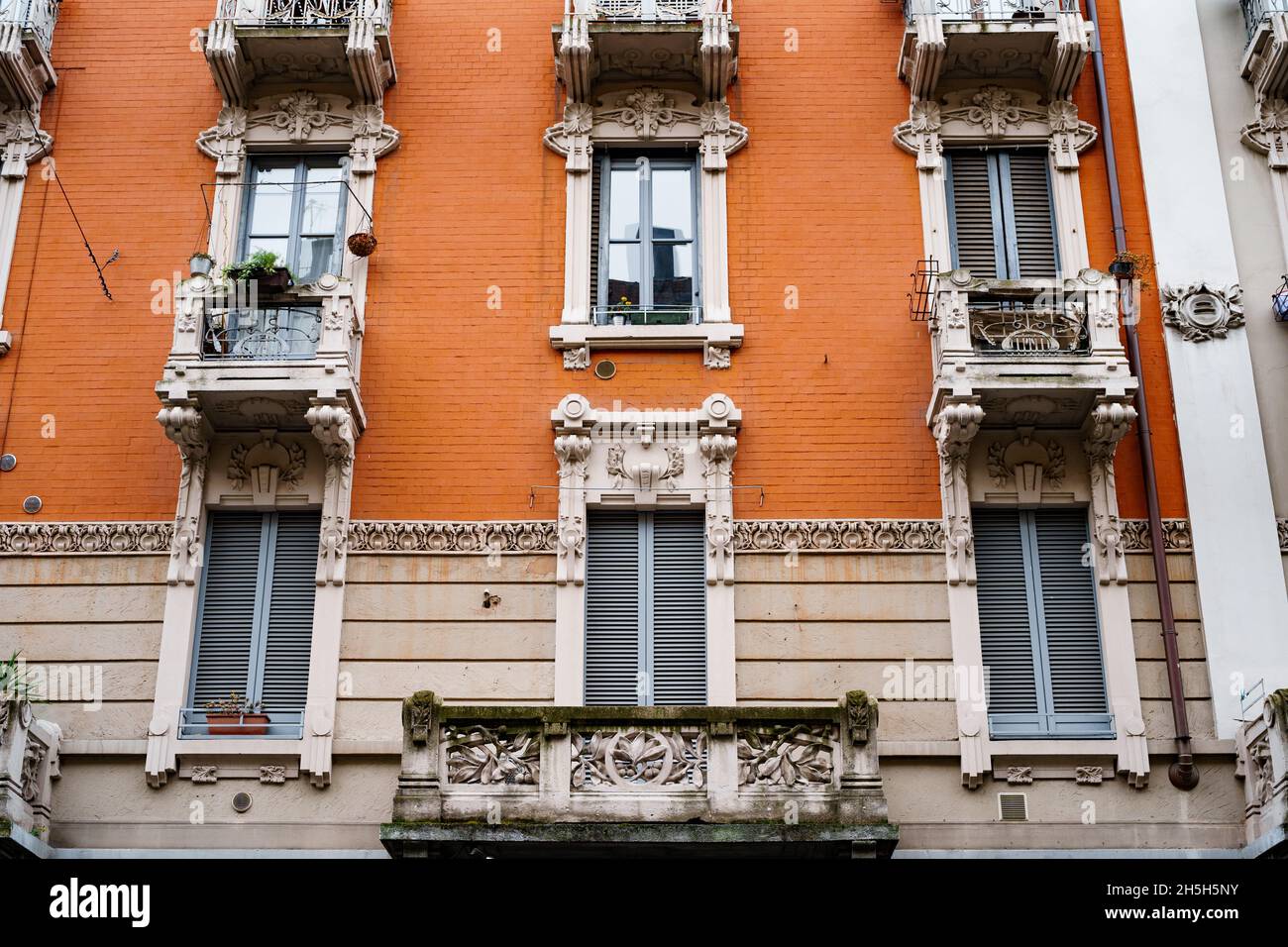 Balconi in pietra intagliata e cornici sopra le finestre della vecchia  casa. Milano, Italia Foto stock - Alamy