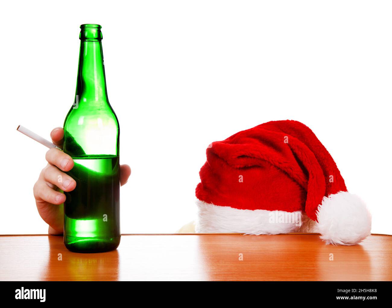 Persona in cappello di Babbo Natale con la birra e la sigaretta al tavolo sullo sfondo bianco Foto Stock