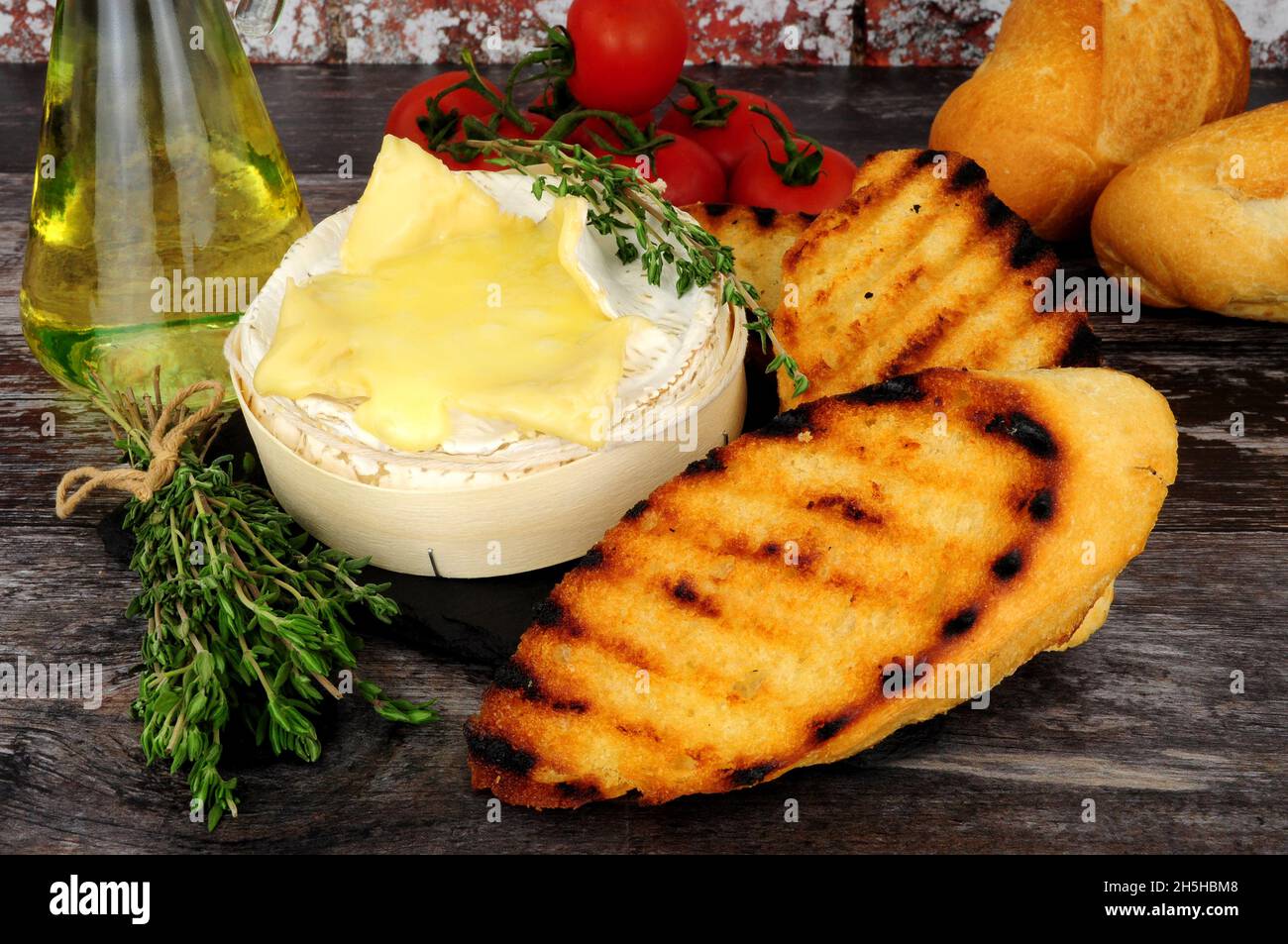 Cremoso camembert francese al forno con pane tostato croccante Foto Stock