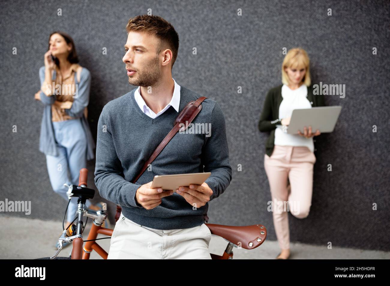 Gruppo di persone aziendali che utilizzano dispositivi elettronici all'aperto Foto Stock