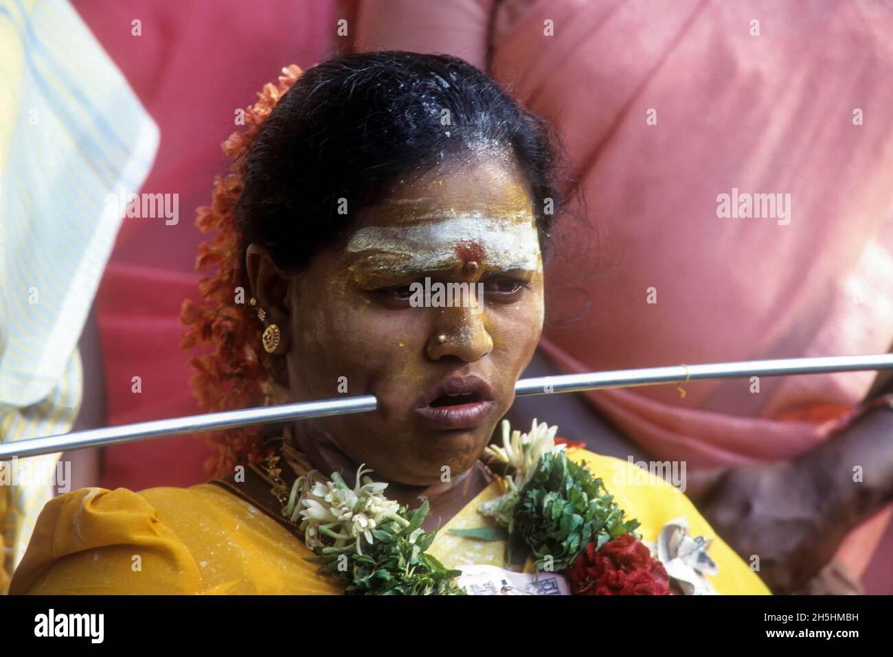 Donna piercing ferro asta attraverso guance scarico voto, Mariamman festival a Coimbatore, Tamil Nadu, India Foto Stock