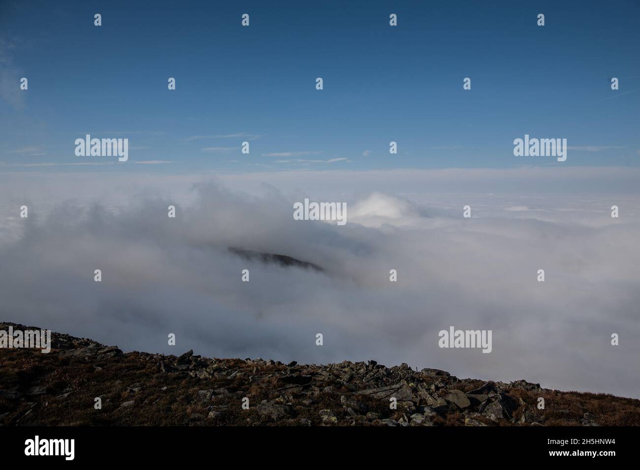 Spesso strato di nuvole in cima alla montagna | vista mozzafiato sulla cima della montagna sopra le nuvole in giorno di sole tempo incredibile Foto Stock