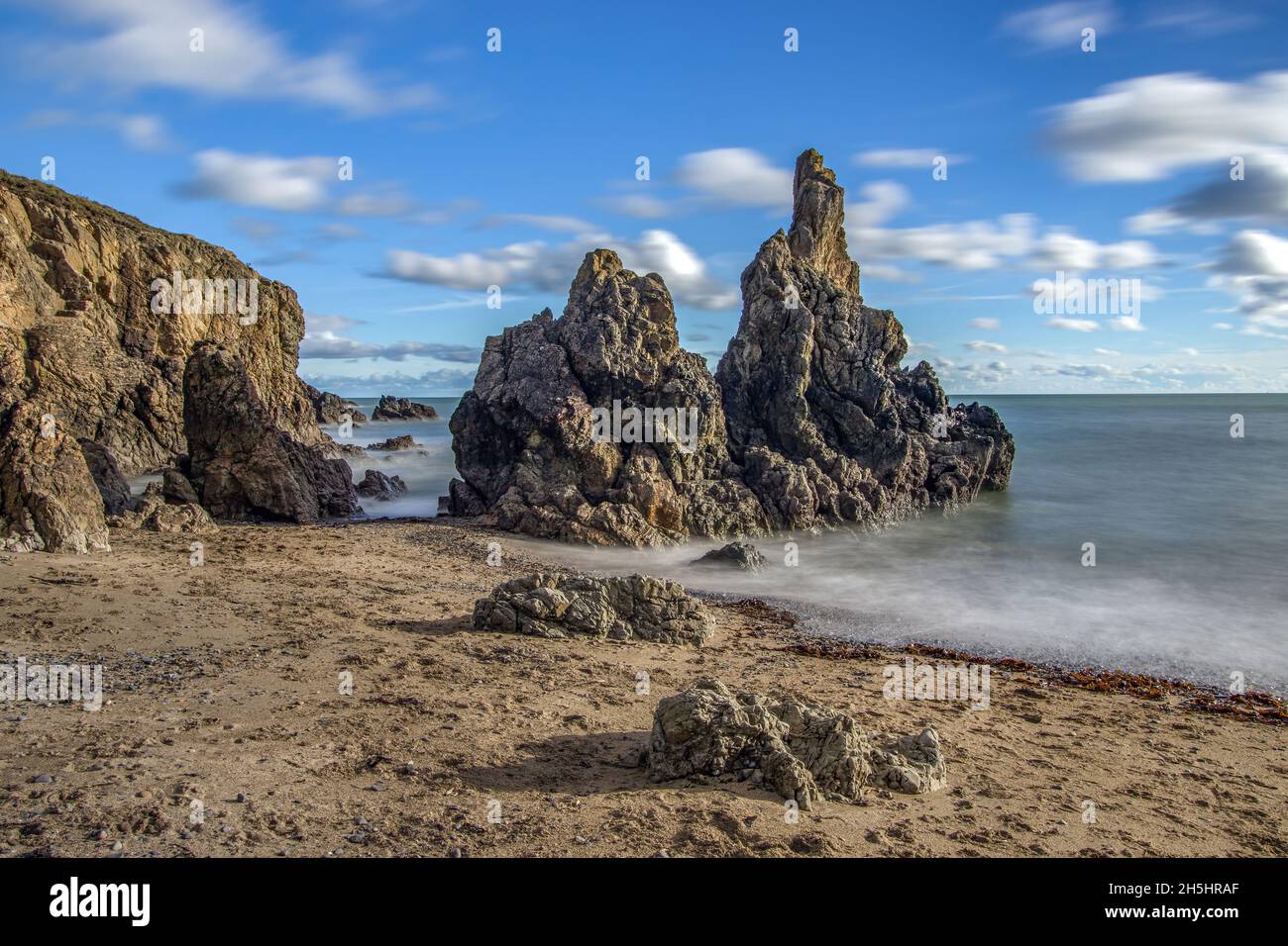 La penisola di Howth Head in giornata soleggiata e nuvolosa, esposizione a lungo, Dublino County, Seashore di scogliere, baie e rocce paesaggio, Irlanda Foto Stock